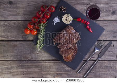 Grilled Striploin Beef Steak With Wine Glass And Vegetables. Top View On Stone Plate. Copy Space
