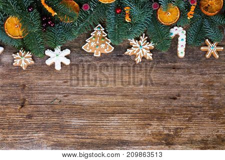christmas gingerbread iced cookies with fir tree flat lay border, copy space on wooden background