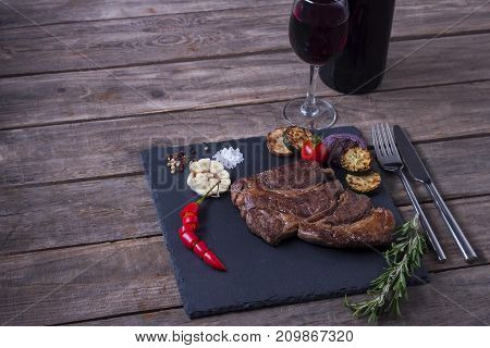 Grilled Beef Striploin Steak From Black Angus And Vegetables On Stone Plate. Salt And Papper. Red Wi