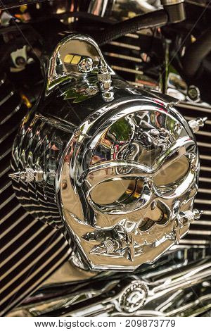 A decorative cap in the form of a skull on a motorcycle engine.