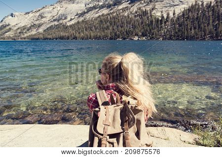 woman sitting at a lake in Yosemite Park.