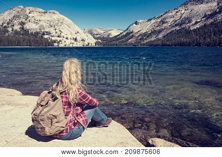 woman sitting at a lake in Yosemite Park.