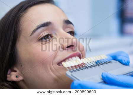 Close up of dentist holding equipment while examining woman at medical clinic