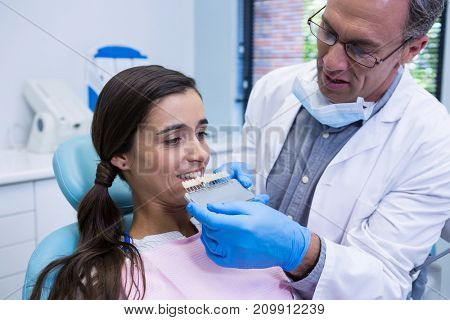 Dentist holding equipment while examining woman at medical clinic