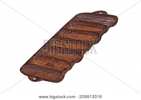 Old rusty cast-iron pan for baking cornbread sticks in the shape of corn on the cob isolated against a white background