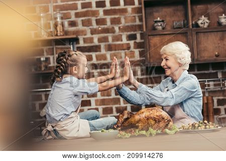 Grandmother And Granddaughter Giving High Five
