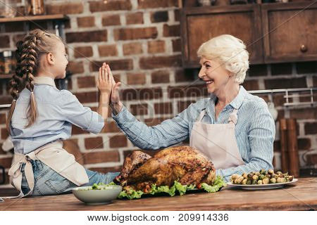 Grandmother And Granddaughter Giving High Five