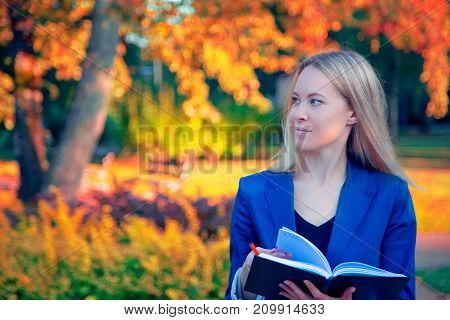 Autumn portrait of a beautiful happy woman outdoors