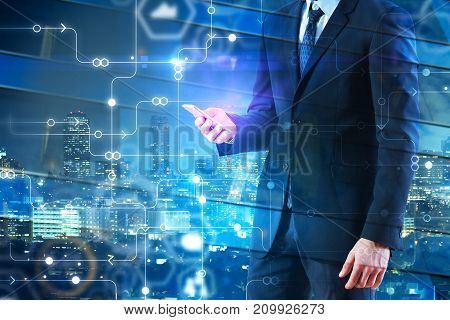 Side view of businessman holding smartphone on abstract city background with digital circuit. Innovation concept. Double exposure