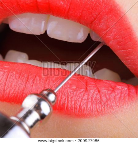 Steel needle in the woman's mouth. Macro photo