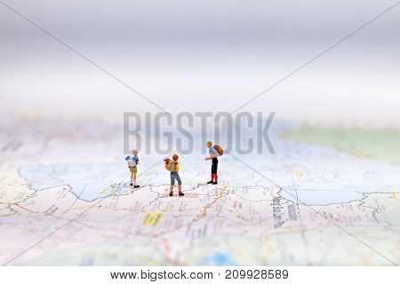 Miniature Group traveler with backpack standing on wold map for travel around the world. Travel Concept select focus