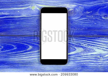 Mobile phone with blank screen mock up isolated on blue wood table background. Smartphone on wood table. Smartfone white