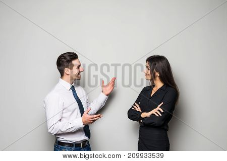 Smiling Businesswoman And Businessman Are Conversing Against Grey Background.