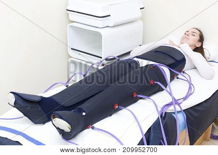 Woman at the clinic for the treatment of pressure therapy procedure