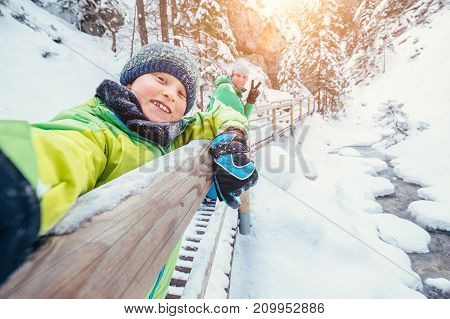 Boy take a selfie picture with his father in snow mountain canyo