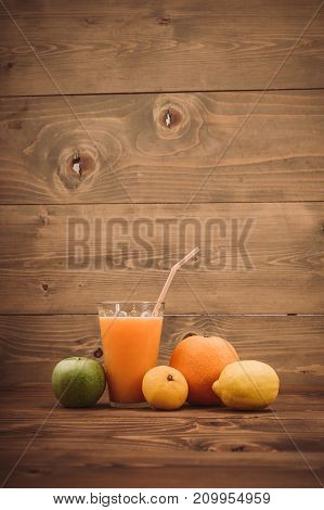 Orange Juice In Glass And Fresh Fruits On Wooden Background