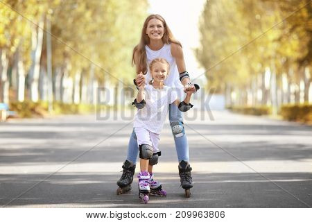 Mother with daughter rollerskating in park