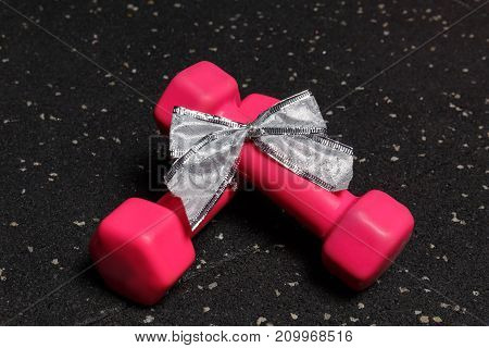 Small dumbbells red for fitness on a black background of the floor