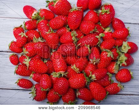 Fresh ripe fruits on a gray wooden table. Sweety red strawberries summer fruits on a gray background. Close-up of strawberry. Food concept.