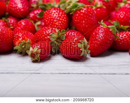 Fresh ripe fruits on a gray wooden table. Sweety red strawberries summer fruits on a gray background. Close-up of strawberry. Food concept.