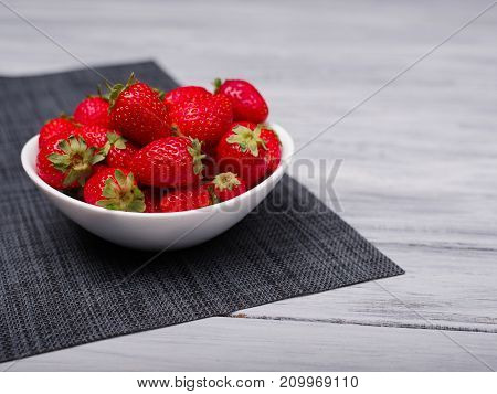 Fresh ripe fruits on a gray wooden table. Sweety red strawberries summer fruits on a gray background. Close-up of strawberry. Food concept.