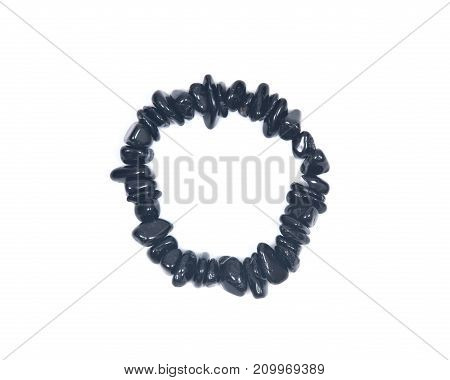 Black Tourmaline Bracelet isolated on white background. Polished tumbled black tourmaline stones strung on stretch cord.