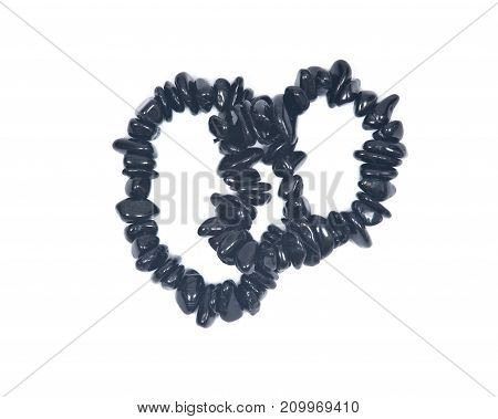 Black Tourmaline Bracelet isolated on white background. Polished tumbled black tourmaline stones strung on stretch cord.