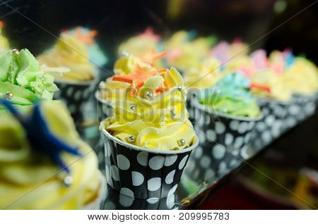 colorful cupcakes frosted with a variety of frosting flavors.