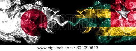 Japan Vs Togo, Togolese Smoky Mystic Flags Placed Side By Side. Thick Colored Silky Smokes Combinati