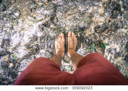 Hiking Outdoors In The Forest: Cut Out Of Male Barefoot Feet In A Shallow River, Fresh Water