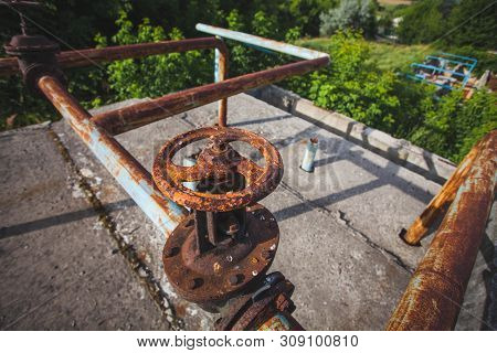 An Old Rusty Gas Control Valve On The Wall. Industrial Valve In A Large System. Rusty Pipes. Old Wat