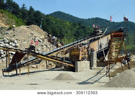 Wonsan, North Korea - May 4, 2019: Stone Crushing Machine Operated  By Soldiers In Construction Site