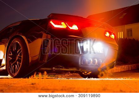 Us Sports Car At Night With Glowing Taillights