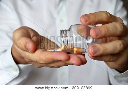 Doctor With Bottle Of Pills, Therapist Giving Medication In Capsules. Concept Of Dose Of Drugs, Vita