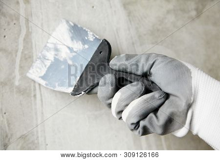 Abstract Photo Of Wall Finishing Work, Trowel In The Hands Of A Worker At A Construction Site, Decor