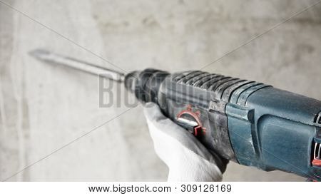 Abstraction Photo Of Noisy Repair. Electric Tool In The Hands Of A Construction Worker, Gadder Again
