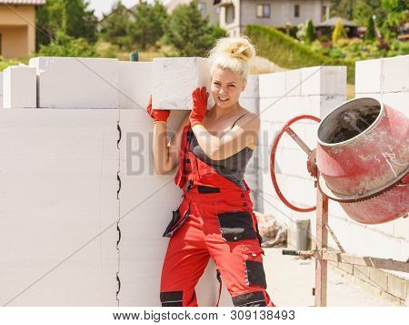 Strong Pretty Woman Working On Construction Site, Building House, Installing Gray Airbricks. Industr