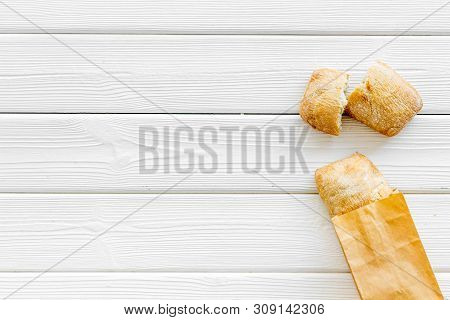 Fresh Baguette And Paper Bag For Bakery On White Wooden Background Top View Mock-up