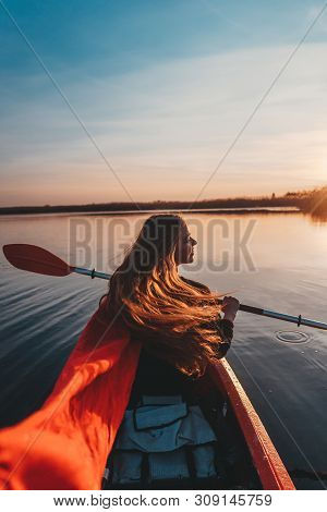 Back View Of Happy Cute Girl Holding Paddle In A Kayak On The River