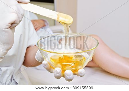Cosmetologist Master Holding Bowl With Hot Wax For Depilation Epilation Hair Removal Procedure And F