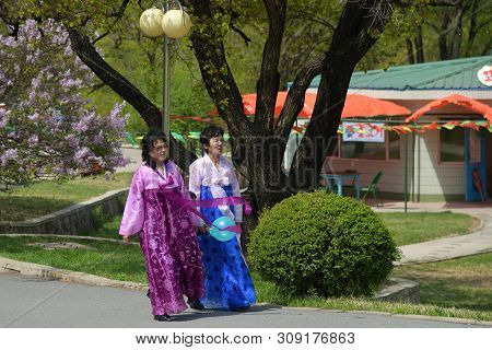 Pyongyang, North Korea - May 1, 2019: An Adult Women In Traditional Korean Clothes Walking In The Ta