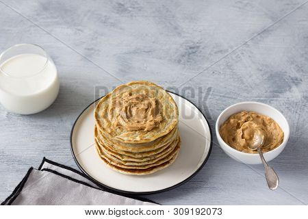 Vegan Pancakes With Flax Seeds, Peanut Butter And Vegan Milk On A White Plate On A Gray Background. 