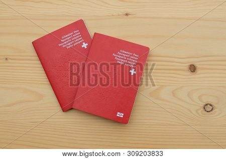 Top View Of Two Swiss Passports On A Wooden Table