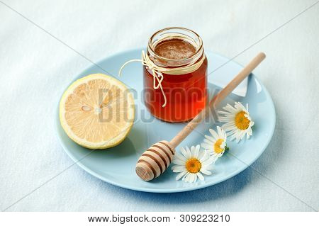 Chamomile Flowers And Chamomile Tea. Chamomile Tea In Glass Teacup With Flowers, Honey And Lemon, To