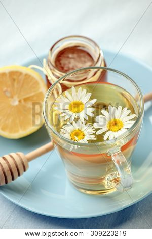 Chamomile Flowers And Chamomile Tea. Chamomile Tea In Glass Teacup With Flowers, Honey And Lemon, To