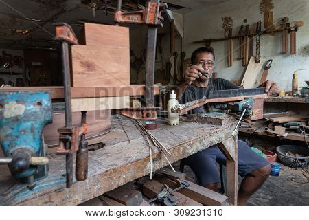 Gianyar,bali/indonesia-may 30 2019: A Guitar Craftsman Is Measuring And Make Sure It Is A Precision