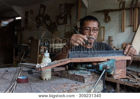 Gianyar,bali/indonesia-may 30 2019: A Guitar Craftsman Is Measuring And Make Sure It Is A Precision