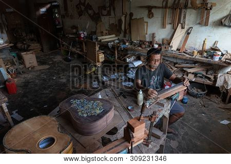 Gianyar,bali/indonesia-may 30 2019: A Guitar Craftsman Is Measuring And Make Sure It Is A Precision