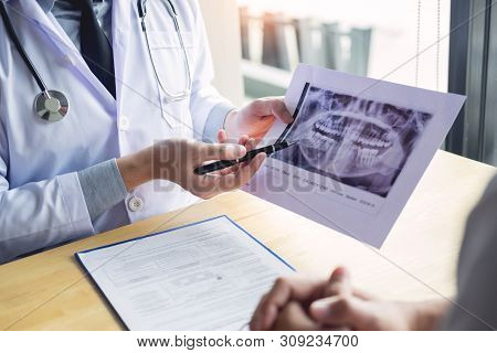 Dental Hygienist Demonstrating And Showing A Dummy Jaw To Chack-up Or Healing Teeth  Patient