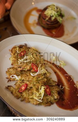 Healthy vegeterian food on brown wood board. Spring vitamin dieting food. Potato vegan pancakes with juice fruit and vegetables